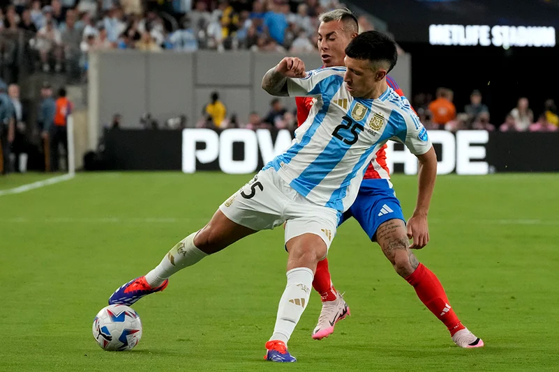 Lisandro Martinez and Eduardo Vargas battle for the ball